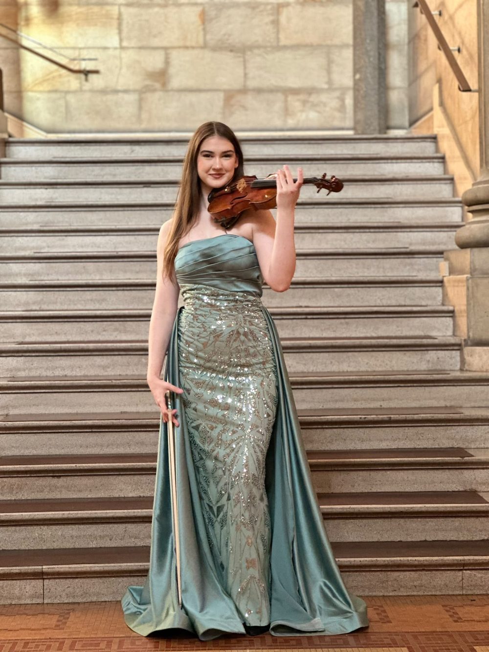 Anna-Emilia Mühlheim mit ihrer Violine auf einer Steintreppe